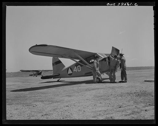 Bar Harbor, Maine. Civil Air Patrol base headquarters of coastal patrol no. 20. Ground crew tuning up a plane before the dusk patrol