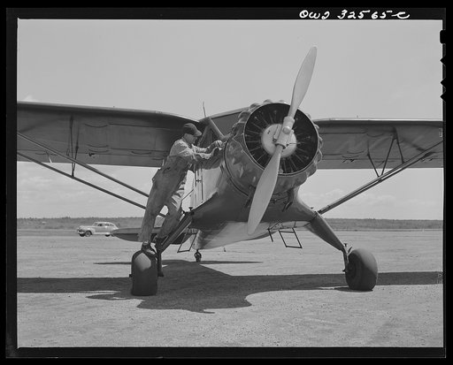 Untitled photo, possibly related to: Bar Harbor, Maine. Civil Air Patrol base headquarters of coastal patrol no. 20. Ground crew tuning up a plane before the dusk patrol