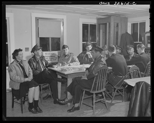 Untitled photo, possibly related to: Bar Harbor, Maine. Civil Air Patrol base headquarters of coastal patrol no. 20. Personnel warming up in the canteen before the dawn patrol. The woman at the near end of the table works in the control tower