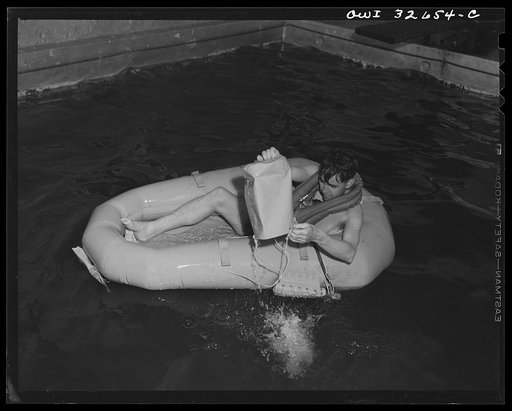 Bar Harbor, Maine. Civil Air Patrol base headquarters of coastal patrol no. 20. A flyer testing a rubber crash boat; he is bailing out the boat with a combination bucket and sea anchor