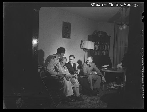Untitled photo, possibly related to: Oswego, New York. Canadian flight commander and Polish naval officers visiting in the home of a Polish-American family