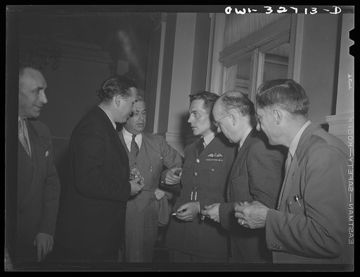 Untitled photo, possibly related to: Oswego, New York. A Czechoslovakian flier in the Royal Air Force chats with the Czech consul and a Rotarian at the Rotary Club luncheon during United Nations week