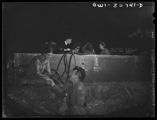 Untitled photo, possibly related to: Oswego, New York. Dutch Army officer and a British naval officer, accompanied by the plant's general manager, chatting with a welder in the Fitzgibbons tank factory during United Nations week