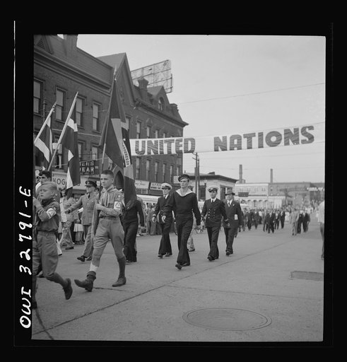 Untitled photo, possibly related to: Oswego, New York. United Nations heroes marching behind the boy scouts carrying flags in the United Nations week parade
