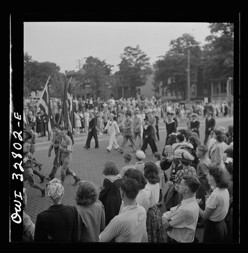 Untitled photo, possibly related to: Oswego, New York. United Nations heroes marching in the Flag Day parade on Bridge Street, decorated with United Nations seals (left)