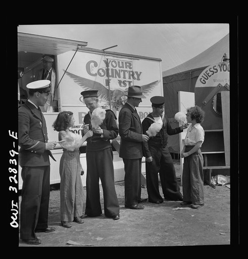Untitled photo, possibly related to: Oswego, New York. A Belgian sailor giving sponge sugar to a little girl at the carnival during United Nations week