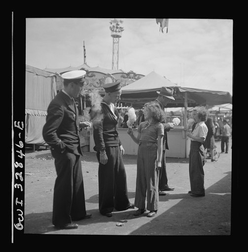 Untitled photo, possibly related to: Oswego, New York. A Belgian sailor giving sponge sugar to a little girl at the carnival during United Nations week