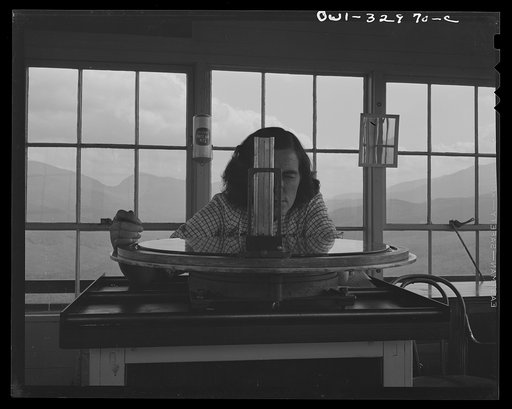 Untitled photo, possibly related to: Gorham (vicinity), New Hampshire. Barbara Mortensen, a fire and airplane lookout on Pine Mountain, sighting suspicious smoke through a fire finder so as to locate accurately its source by cross bearings on the topographical chart