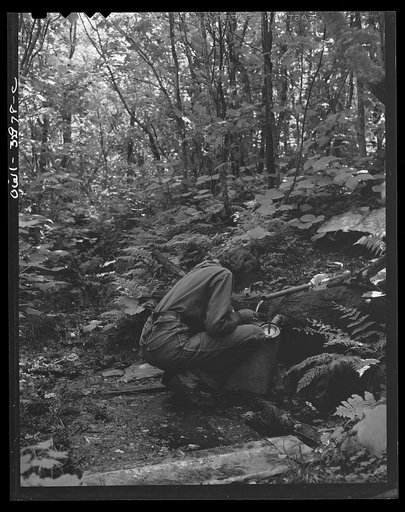 Untitled photo, possibly related to: Gorham (vicinity), New Hampshire. Barbara Mortensen, a fire and airplane lookout on Pine Mountain, filling her metal pack to carry back up one half mile of trail to the fire tower