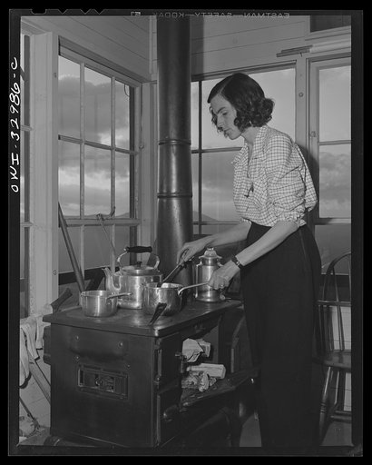 Untitled photo, possibly related to: Gorham (vicinity), New Hampshire. Barbara Mortensen, a fire and airplane lookout on Pine Mountain does all her cooking in the tower. Wood and water must be carried up fifty-six steps from the mountain top below