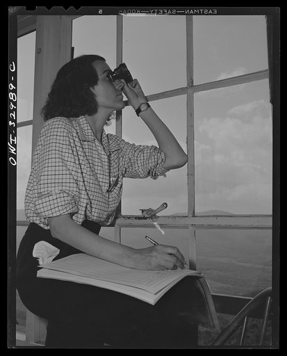 Gorham (vicinity), New Hampshire. Barbara Mortensen, a fire and airplane lookout on Pine Mountain, serves the Interceptor Command as a spotter. Use of binoculars is restricted to identification of planes; actual spotting is done with the naked eyes