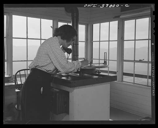 Gorham (vicinity), New Hampshire. Barbara Mortensen, a fire and airplane lookout on Pine Mountain. Upon sighting smoke, she phones in at once to the dispatcher in Gorham, who in turn relays the information to the fire warden of the suspected district