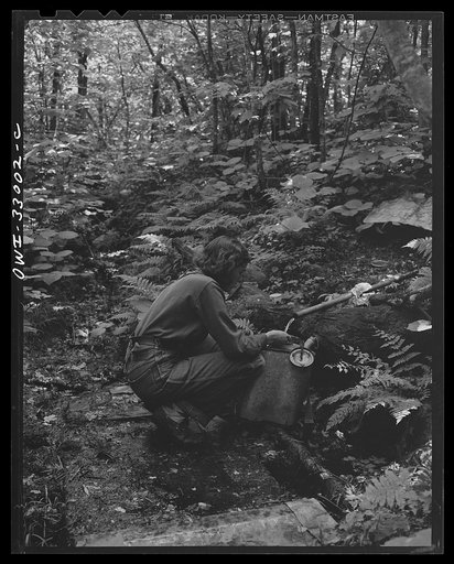 Gorham (vicinity), New Hampshire. Barbara Mortensen, a fire and airplane lookout on Pine Mountain filling her metal tank which she will carry on her back a half mile up the mountain to the fire tower