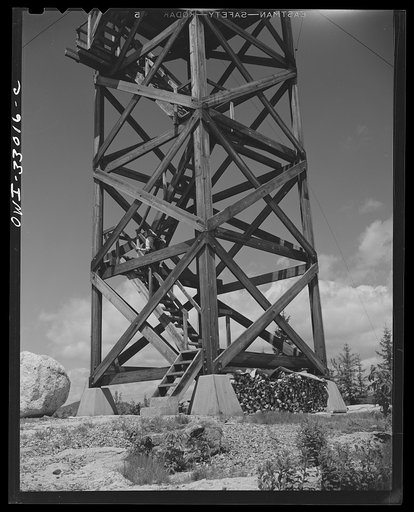 Gorham (vicinity), New Hampshire. Barbara Mortensen, a fire and airplane lookout on Pine Mountain, mounts fifty-six steps to reach the fire tower