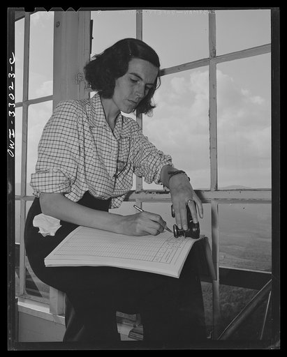 Untitled photo, possibly related to: Gorham (vicinity), New Hampshire. Barbara Mortensen, a fire and airplane lookout on Pine Mountain, serves the Interceptor Command as a spotter. Use of binoculars is restricted to identification of planes; actual spotting is done with the naked eyes