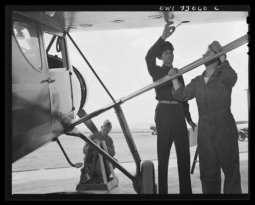 Bar Harbor, Maine. Civil Air Patrol base headquarters of coastal patrol no. 20. The chief engineering officer conducting a routine check of patrol planes in the hanger