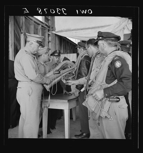 Bar Harbor, Maine. Civil Air Patrol base headquarters of coastal patrol no. 20. Base commander Major James B. King making a routine inspection of "Mae West" life preservers