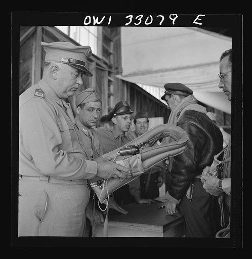 Untitled photo, possibly related to: Bar Harbor, Maine. Civil Air Patrol base headquarters of coastal patrol no. 20. Base commander Major James B. King making a routine inspection of "Mae West" life preservers