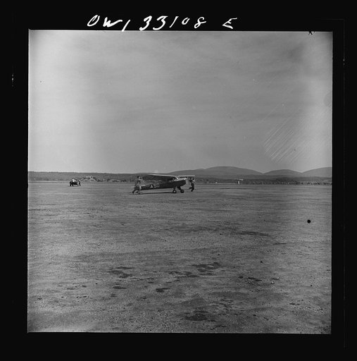 Bar Harbor, Maine. Civil Air Patrol base headquarters of coastal patrol no. 20. Low horsepower plane, used only for courier duty, being steadied in a strong wind by two ground crew men