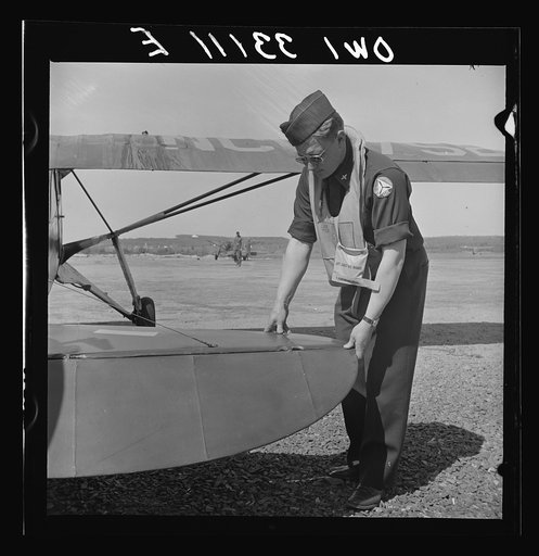 Bar Harbor, Maine. Civil Air Patrol base headquarters of coastal patrol no. 20. Pilot checking the rudder assembly before taking off
