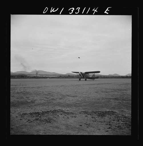 Untitled photo, possibly related to: Bar Harbor, Maine. Civil Air Patrol base headquarters of coastal patrol no. 20. Low horsepower plane, used only for courier duty, being steadied in a strong wind by two ground crew men