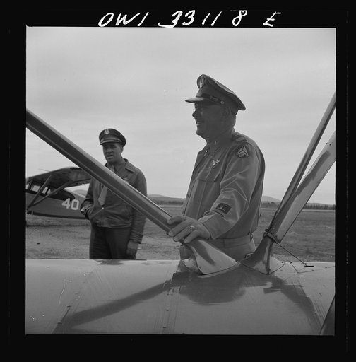 Untitled photo, possibly related to: Bar Harbor, Maine. Civil Air Patrol base headquarters of coastal patrol no. 20. The chief engineering officer conducting a routine check of patrol planes in the hanger