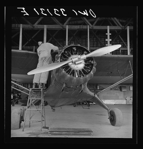 Bar Harbor, Maine. Civil Air Patrol base headquarters of coastal patrol no. 20. Ground crew mechanic working on a patrol plane in the hangar