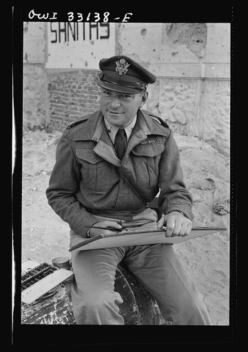 Tripoli, Libya. Lieutenant Milton Marx of New York City, attached to the public relations office of the U.S. Army 9th Air Force, doing some painting in the street. In civilian life, Marx is a commercial artist