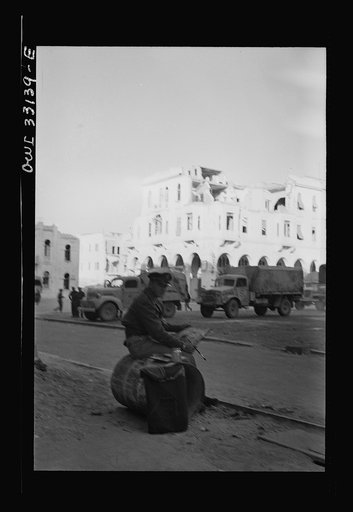 Untitled photo, possibly related to: Tripoli, Libya. Lieutenant Milton Marx of New York City, attached to the public relations office of the U.S. Army 9th Air Force, doing some painting in the streets. In civilian life, Marx is a commercial artist