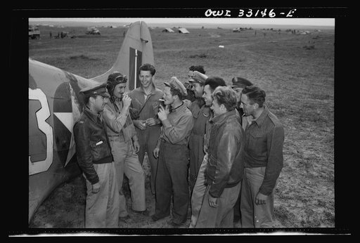 Untitled photo, possibly related to: Major Glade B. Bilby of Skidmore, Montana talking to members of his flying squadron somewhere in Tunisia. While flying top cover, the squadron destroyed six German Messerschmitt