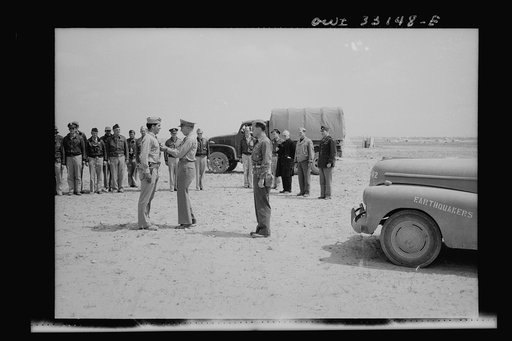 An American sergeant receiving a decoration during the North African campaign. Archbishop Spellman of New York is watching the ceremony