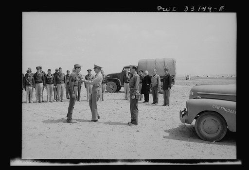 An American sergeant receiving a decoration during the North African campaign. Archbishop Spellman of New York is watching the ceremony