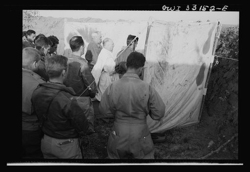Archbishop Francis J. Spellman of New York touring the North African battle front, saying mass for the men at the 57th Fighter Group of the U.S. Army 9th Air Force. This group, located "somewhere in Tunisia," knocked almost 100 Axis transports and fighters out of the skies in one engagement