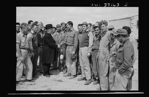 Monsignor Spellman shaking hands with Corporal George T. Robinson while touring the Tunisia front. When Archbishop Francis J. Spellman handed a diploma to Robinson at the Fordham University commencement in New York City in 1937, neither had the remotest idea that they would meet again at a United St