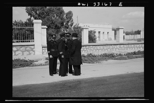 Sfax, Tunisia. Archbishop Spellman of New York talking with French officials on the streets. The official with the braid on his sleeve is the governor of Sfax, Monsieur R. Lement