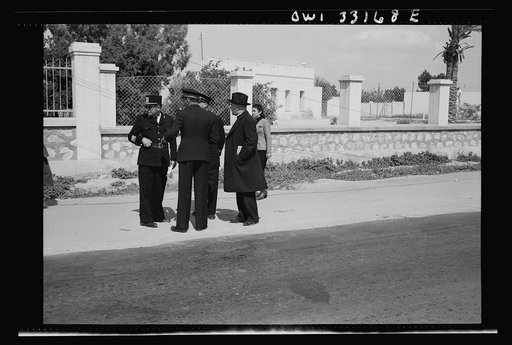 Untitled photo, possibly related to: Sfax, Tunisia. Archbishop Spellman of New York talking with French officials on the streets. The official with the braid on his sleeve is the governor of Sfax, Monsieur R. Lement