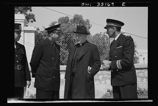 Sfax, Tunisia. Archbishop Spellman of New York talking with French officials on the streets. The official with the braid on his sleeve is the governor of Sfax, Monsieur R. Lement