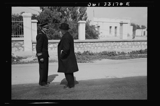 Untitled photo, possibly related to: Sfax, Tunisia. Archbishop Spellman of New York talking with French officials on the streets. The official with the braid on his sleeve is the governor of Sfax, Monsieur R. Lement
