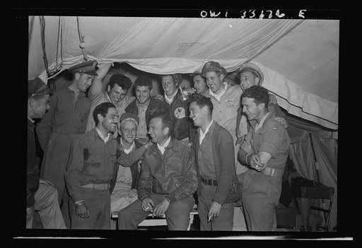 Lieutenant Colonel William K. McKnown, of Lawrence, Kansas, commander of the 314th Squadron of the 57th Fighter Group (center, wearing leather jacket) talking to his two aces, who each shot down five enemy planes over the Sicilian straits on April 18th; Lieutenant Duffey on his right and Lieutenant 