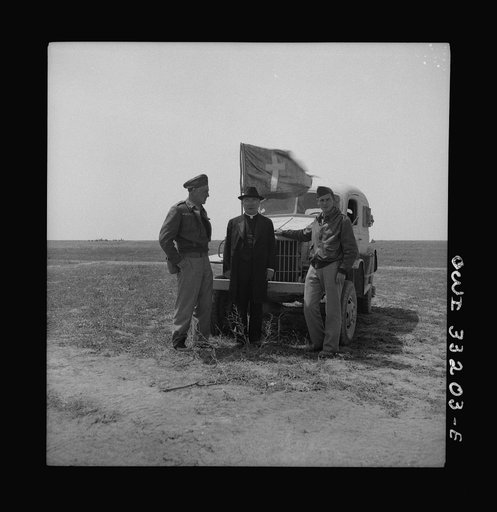 Archbishop Spellman of New York visiting with officers and men at 57th Fighter Group, Tunisia. Left to right: Captain J. E. McGarrity, Paulist priest, New York City; Archbishop Spellman; and Captain C. H. Logue, Catholic chaplain from Cleveland, Ohio