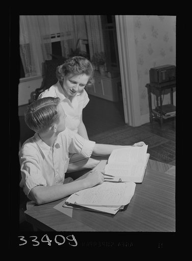 Untitled photo, possibly related to: Keysville, Virginia. One of the teachers in the school helping her brother, a pupil, with his studies. He and his brother run a garage at night. All teachers in the school are local