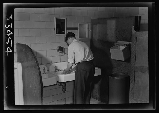 Keysville, Virginia. Randolph Henry High School. A student washing his hands in the lavatory