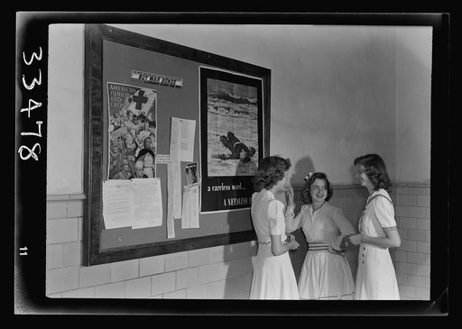 Keysville, Virginia. Randolph Henry High School. Girls in entry hall talking before school in the morning. Bulletin board on wall