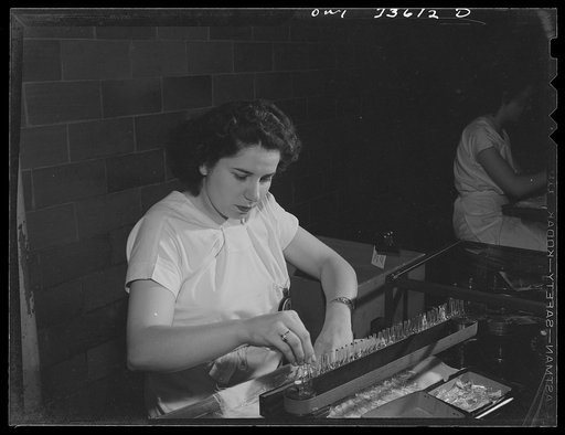 Parke, Davis and Company, manufacturing chemists, Detroit, Michigan. Feeding the automatic labeling machine