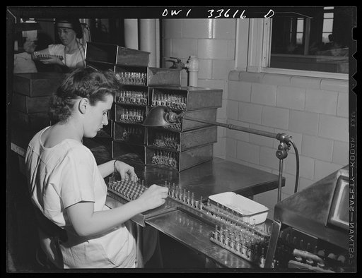 Parke, Davis and Company, manufacturing chemists, Detroit, Michigan. Placing glass ampoules in metal racks preparatory to passing them through an automatic sealing machine