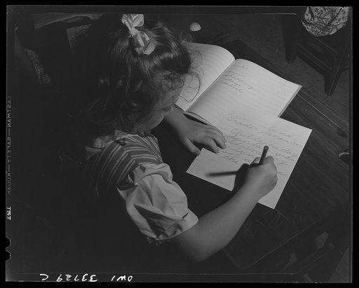 Schenectady, New York. Third grader at the Elmer Avenue Elementary School writing a story on Children's Day. The open notebook is a personal speller