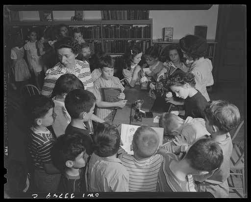 Schenectady, New York. Third graders at the Elmer Avenue Elementary School signing out books from the school library