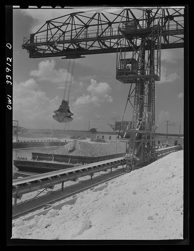 Freeport Sulphur Company, Port Sulphur, Louisiana. Unloading sulphur from a barge to storage vats