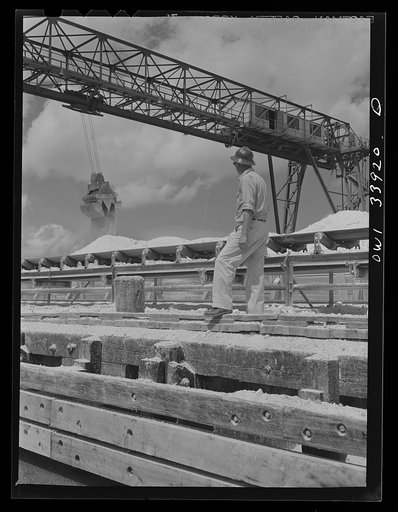 Freeport Sulphur Company, Port Sulphur, Louisiana. Unloading sulphur from a barge to storage vats