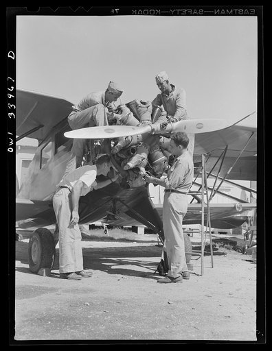 Corpus Christi, Texas. Mechanics working on the motor of a plane at the Civil Air Patrol base